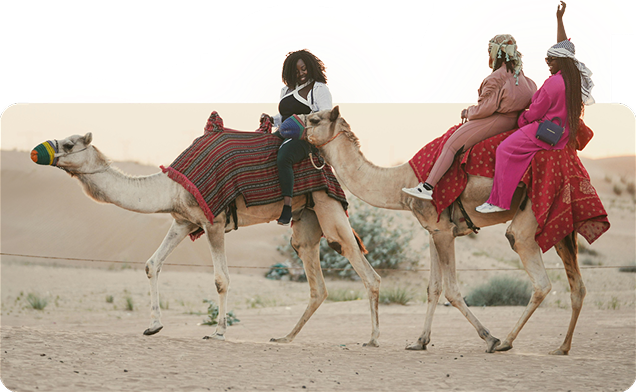 Guests riding camels in the desert